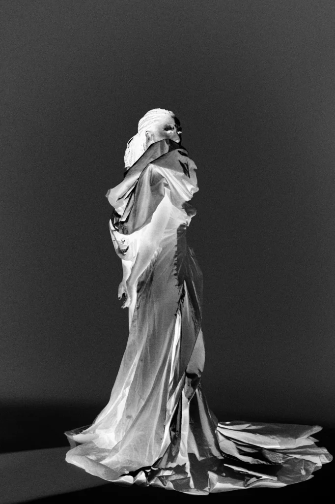 Model in dramatic white silk draped gown with headpiece, avant-garde fashion portrait Berlin studio