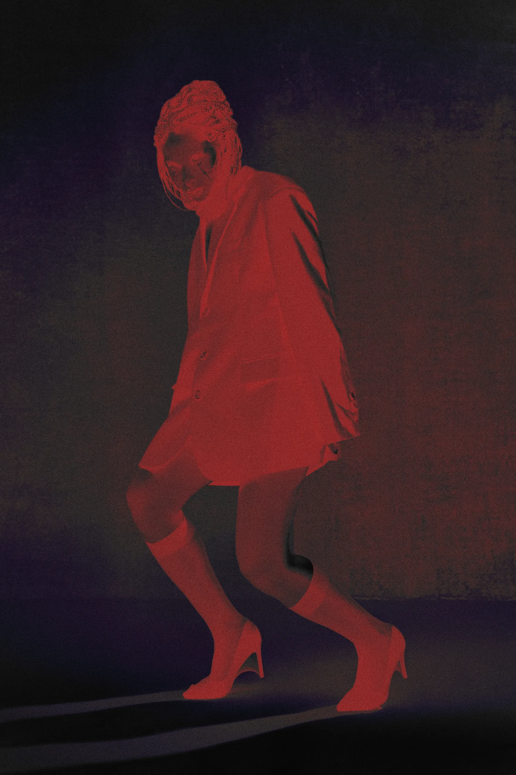 Model in oversized blazer and heels with artistic red lighting, avant-garde fashion editorial berlin